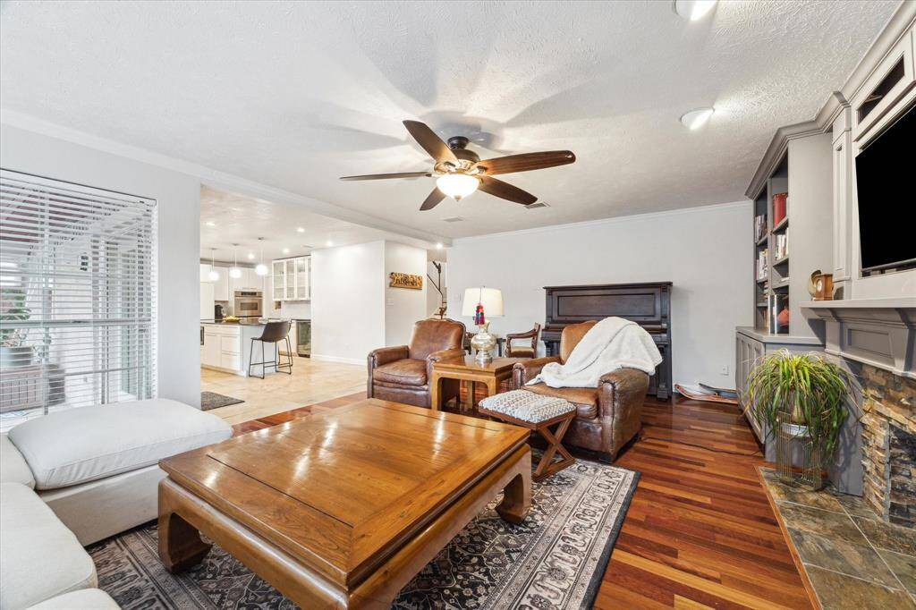 View from the back corner showing how the family room and kitchen seamlessly flow for ONE absolutely LOVELY living space.  Natural stone fireplace features all the beloved earthy tones.