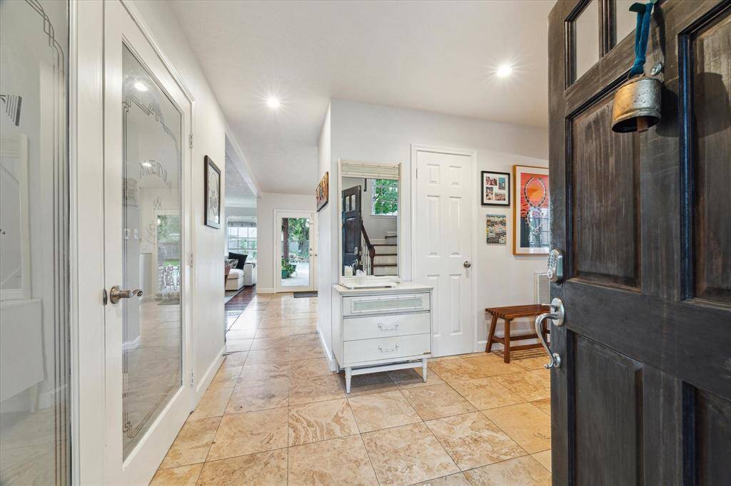 WELCOME IN! The view of the backyard space beckons you in the minute the door is opened! Frosted media room doors on the left lead to a GREAT media space and the formal dining and staircase are to the right. The Travertine floors are gorgeous!