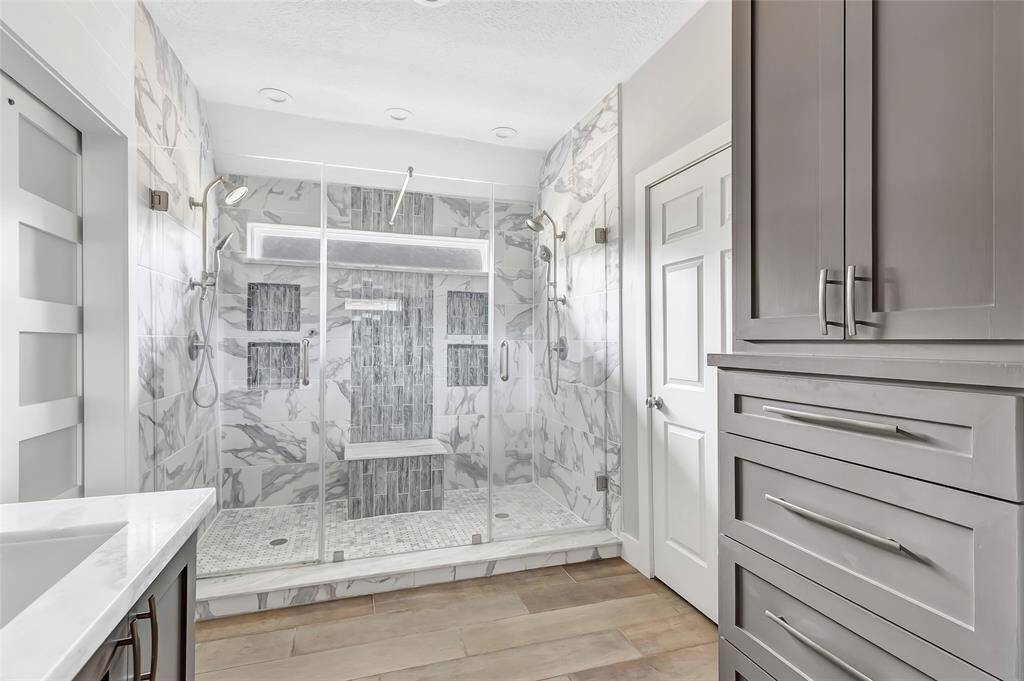 A set of rustic barn doors adds character and charm while providing a stylish entrance to the spa-inspired primary bath.