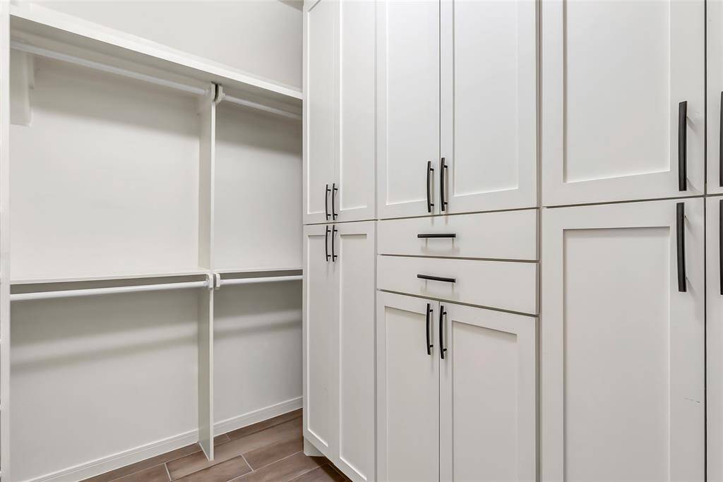 Designed for both style and organization, this expansive primary walk-in closet offers the perfect blend of form and function.