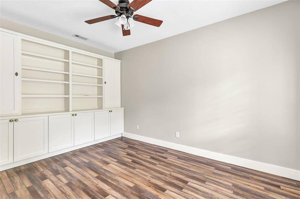 Custom built-in shelving and cabinetry provide ample space for clothing, shoes, and accessories, making it easy to keep everything beautifully organized.