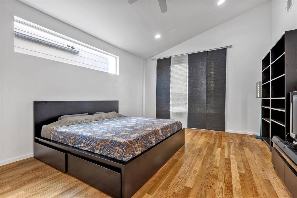 Welcome to the main bedroom, featuring beautiful wooden floors, a large glass window for natural light, and a ceiling fan for added comfort. Create your personal haven in this serene space.