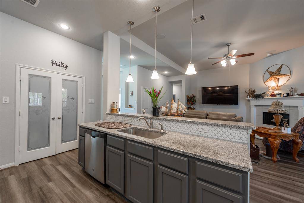 A walk-in pantry, pendant lighting, and a large island with seating make this kitchen both practical and inviting.