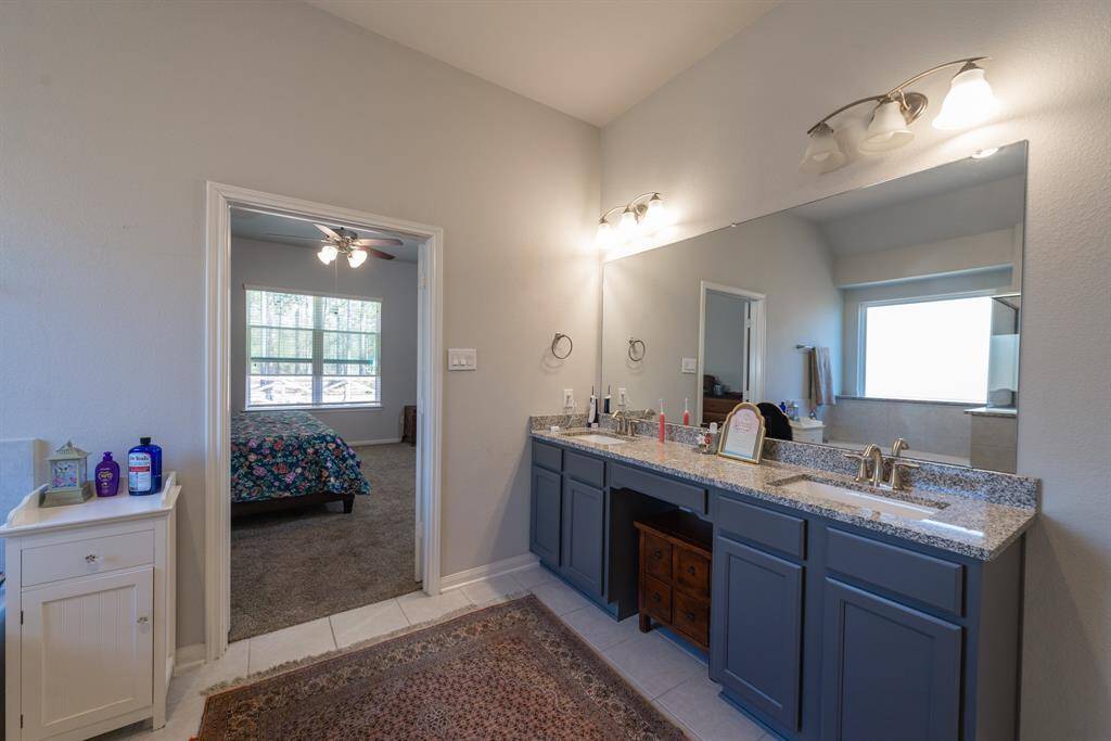 A large mirror and stylish lighting enhance the double vanity, providing ample counter space.