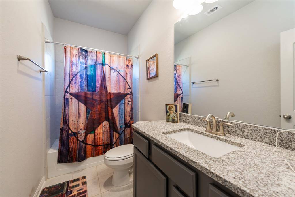 Full bathroom with granite counters.