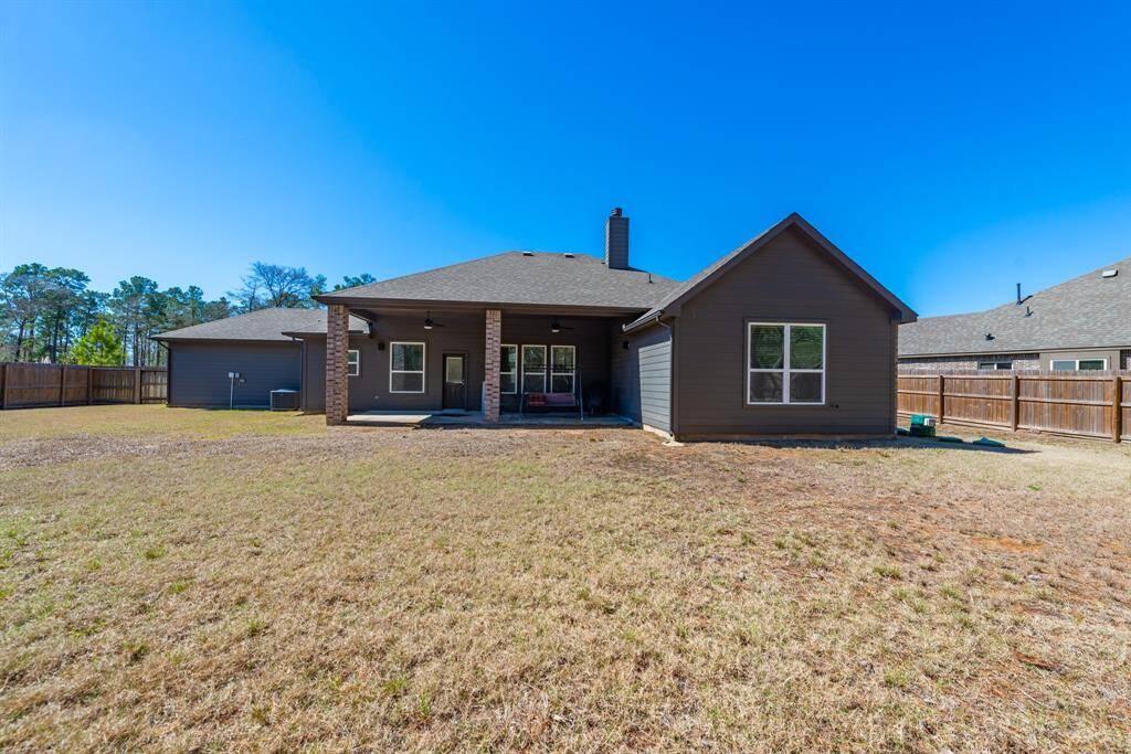 The back of the home showcases the large covered patio, providing shade and comfort for relaxation.