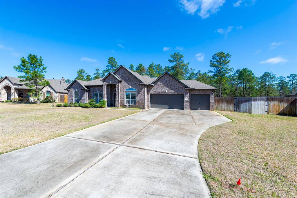 A long driveway leads to a spacious three-car garage, while the brick and stone exterior set a warm and inviting tone.