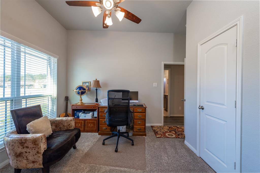 This versatile bedroom, complete with a closet, is currently being used as a home office and features a large window that fills the space with natural light.