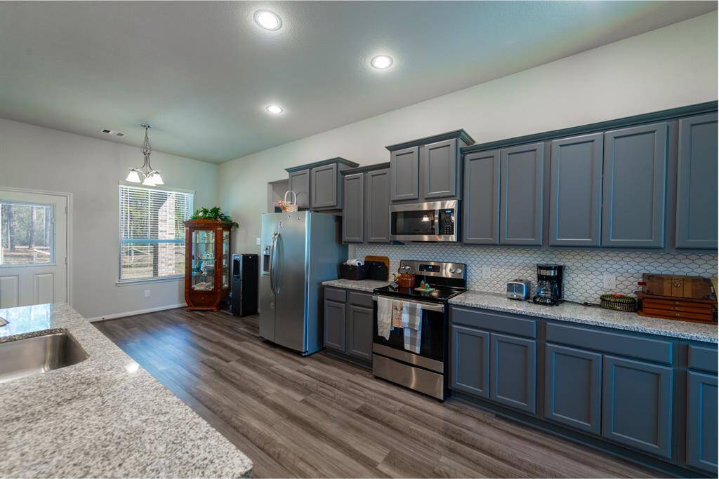 This kitchen stands out with bold gray cabinetry, granite countertops, and an open layout that keeps everything within reach.