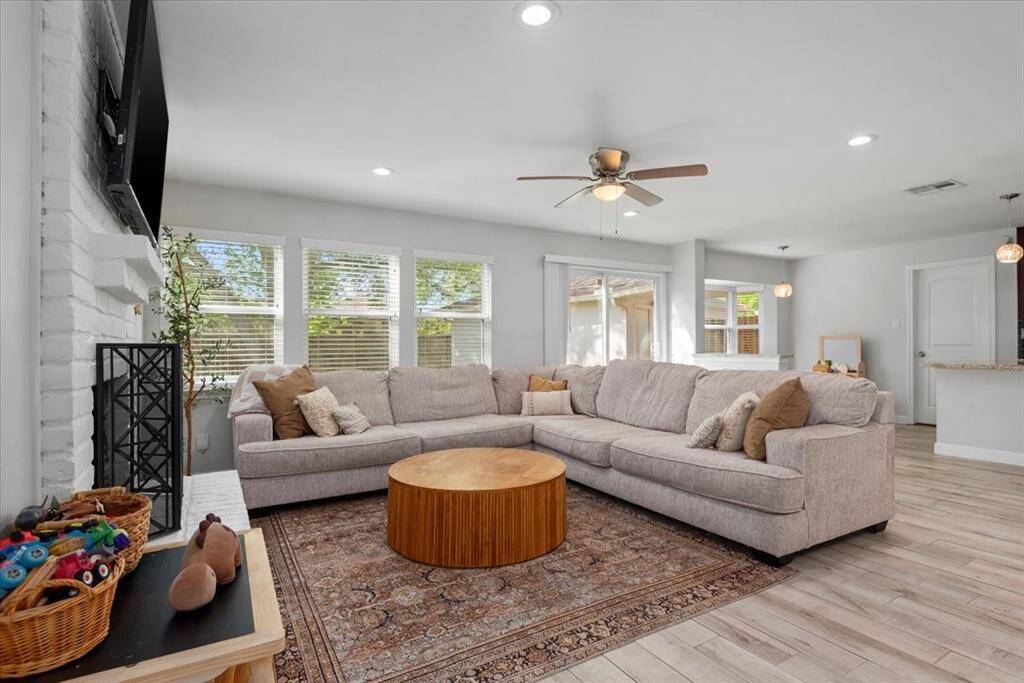 The living room boasts with natural light and a cozy fire place.