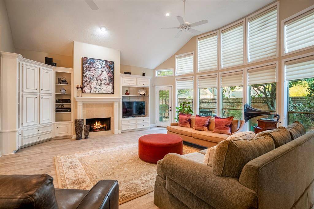 The main living area, with high ceilings, built-ins, a gas fireplace, and a wall of windows looking out to your very private patio.