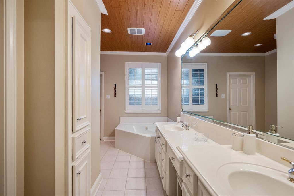 The primary bath boats 2 large closets (his and hers), built-ins, and wood planks on the ceiling.