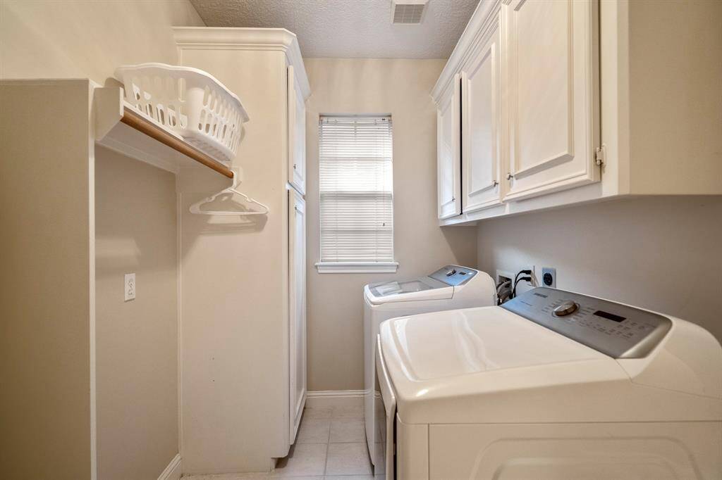 The utility room with a window, built in cabinets and hanging rack for laundry.