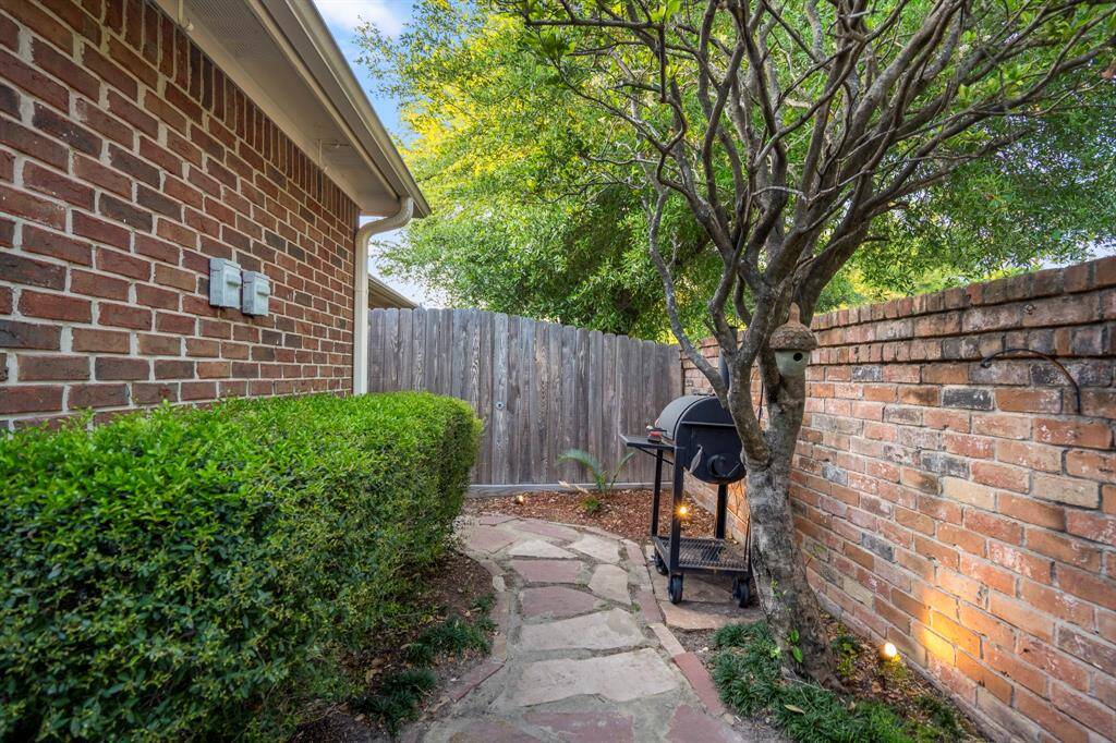 The back yard with pavers and crushed granite, as well as accent lighting.
