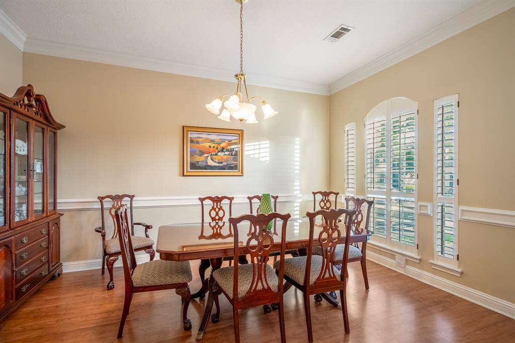 The formal dining room, accented by crown moulding, chair rail, and plantation shutters.