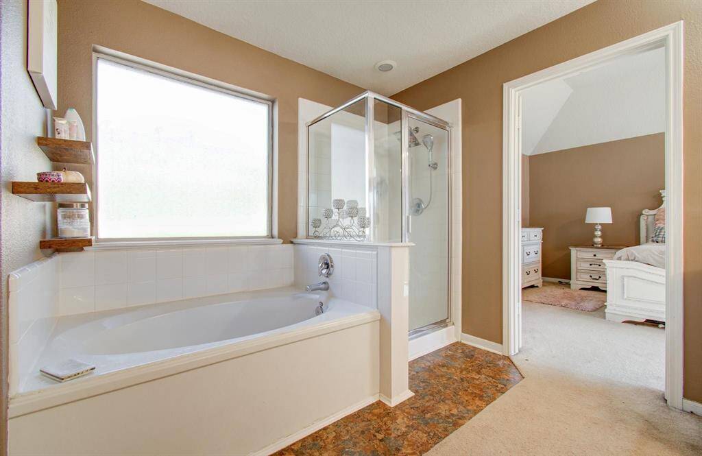 Primary does have separate garden tub and stand up shower enclosure with a large obscured glass window.