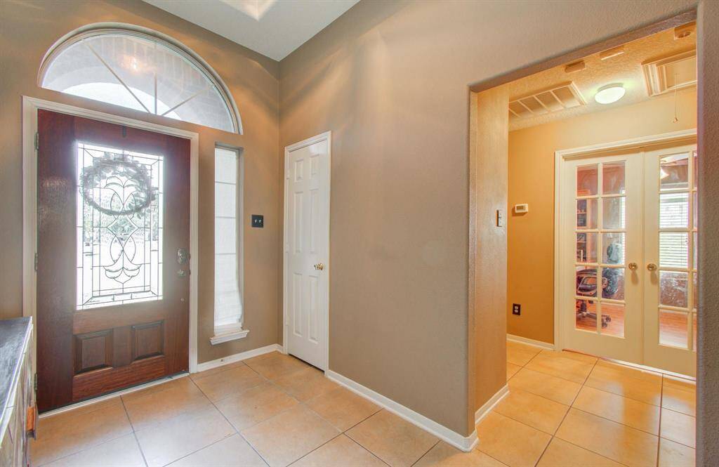 Beautiful upgraded formal tiled entryway with crescent over the door window giving great natural lighting, tray-ceiling, coat closet with office/flex with French door with glass inserts, just a really nice entry in to the home.