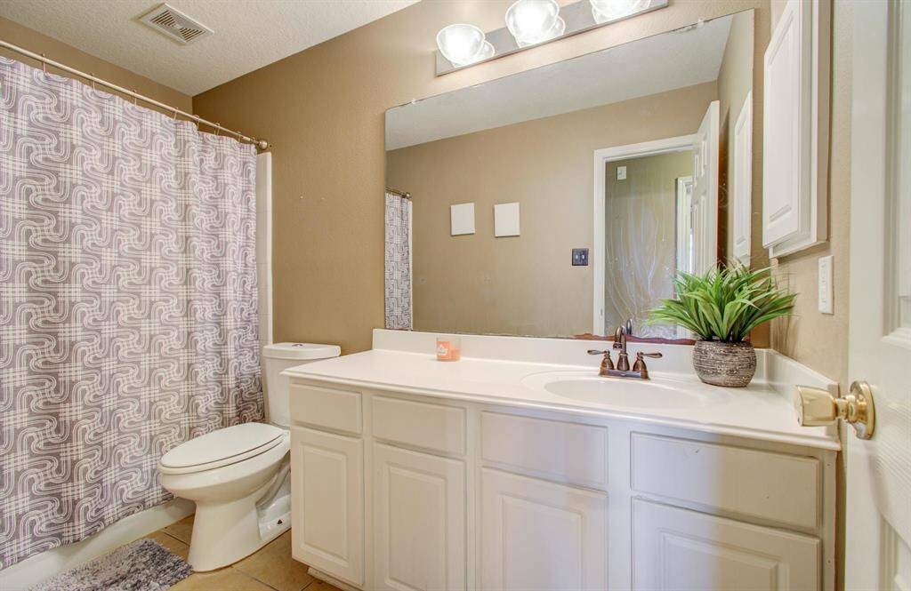 Hall full bath on other side of home with elongated toilet.