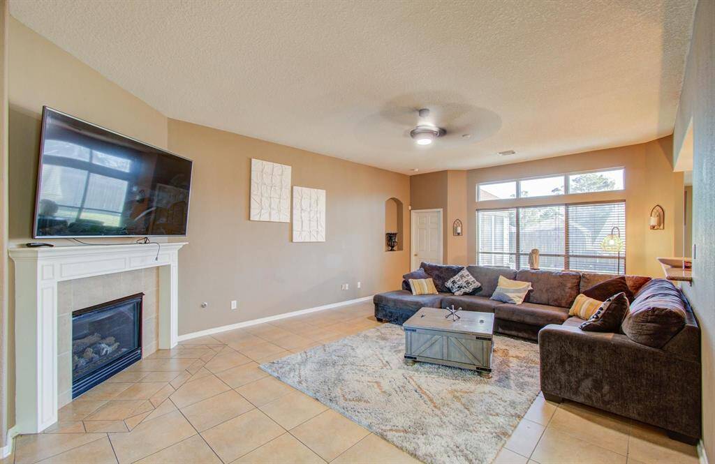 Family room includes a fireplace, tiled floors, elevated ceilings and transoms over the windows adding really good natural lighting to this spacious gathering area.