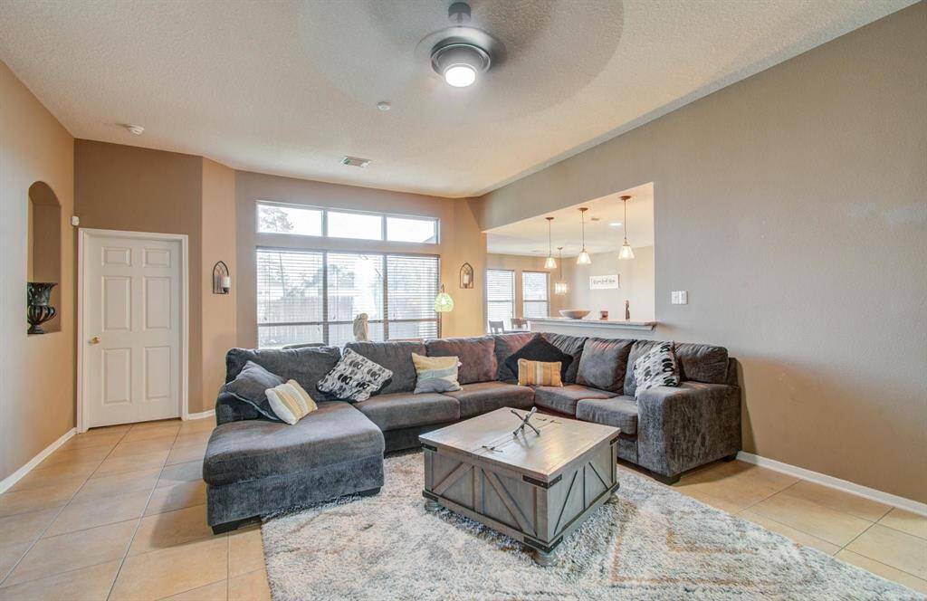 Family room has modern squared arches with bi-level ceilings, nice plentiful amounts of windows and art niche all coming together to provide a pleasant aesthetic.