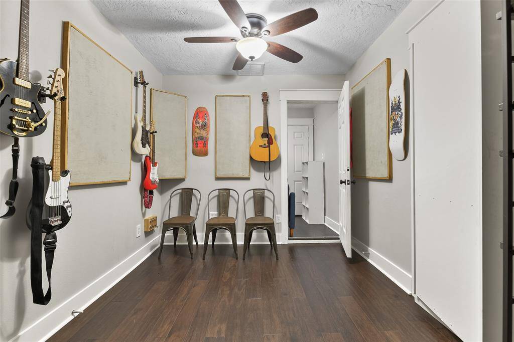 Beyond the bonus room in the previous picture, you'll find another bonus space that takes up one bay of the two-car garage. This room has been used as a music studio and features a lighted ceiling fan, engineered wood floors, and a wood plank accent wall.