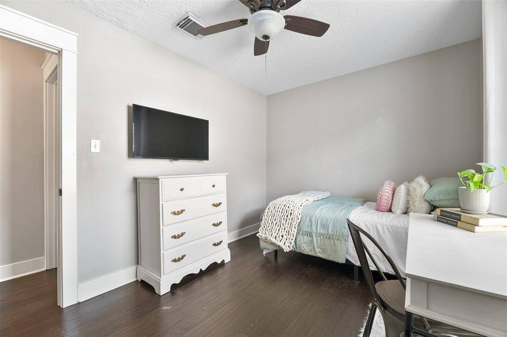 The fourth and final bedroom in the home also offers a lighted ceiling fan, neutral paint, engineered wood flooring, a window with 2-inch blinds, and a roomy closet that maximizes space with built-in shelving and drawers.