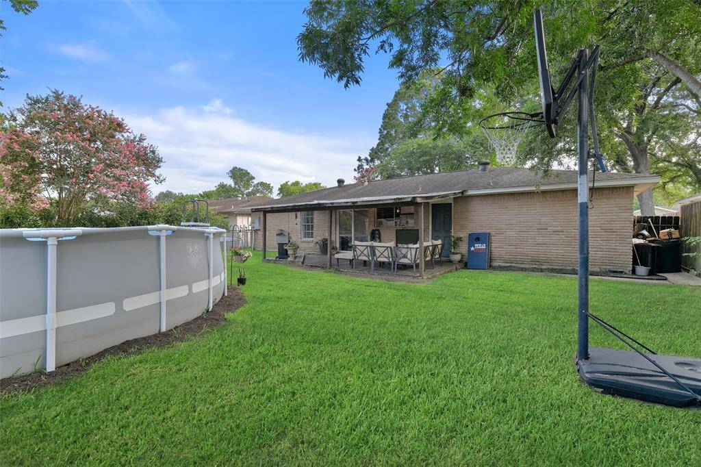 The backyard boasts a large covered patio area and an ample fenced yard. The above-ground pool that is visible in these photos has since been removed.