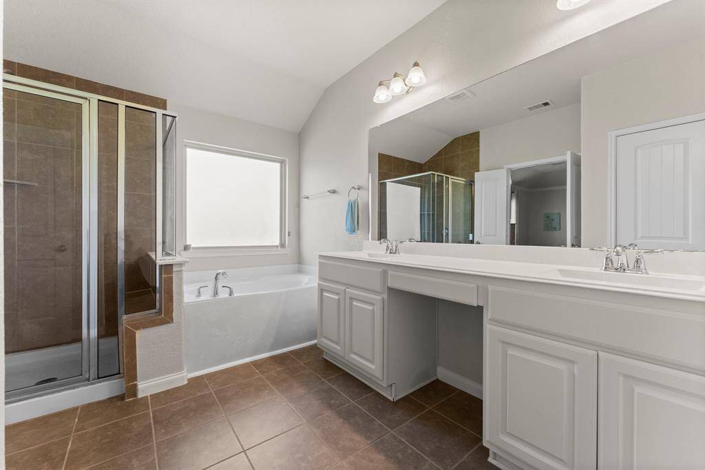 The Primary Bathroom has TWO (2) separate sinks and a vanity area. Separated tub and shower.