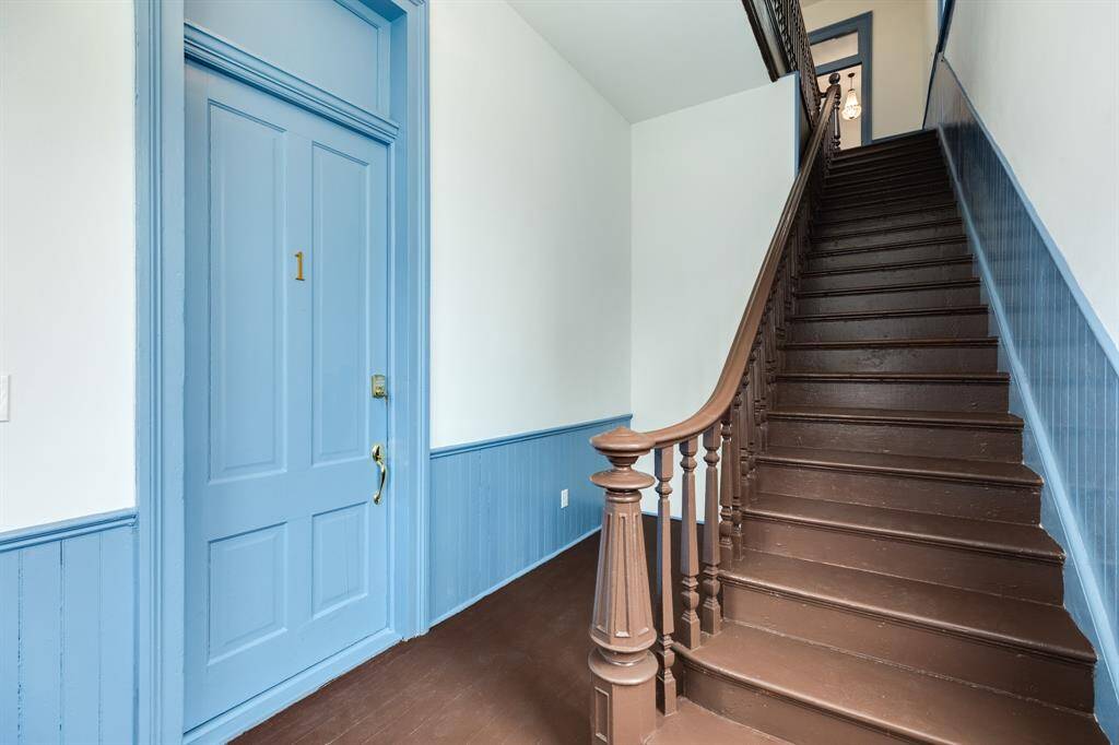 staircase leading to the two upstairs units, downstairs unit to the left