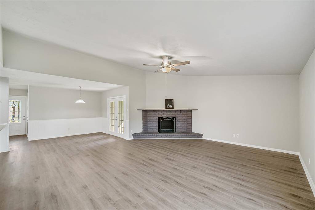 The family room features a lovely fireplace, framed by stylish brick, creating a warm and inviting focal point.