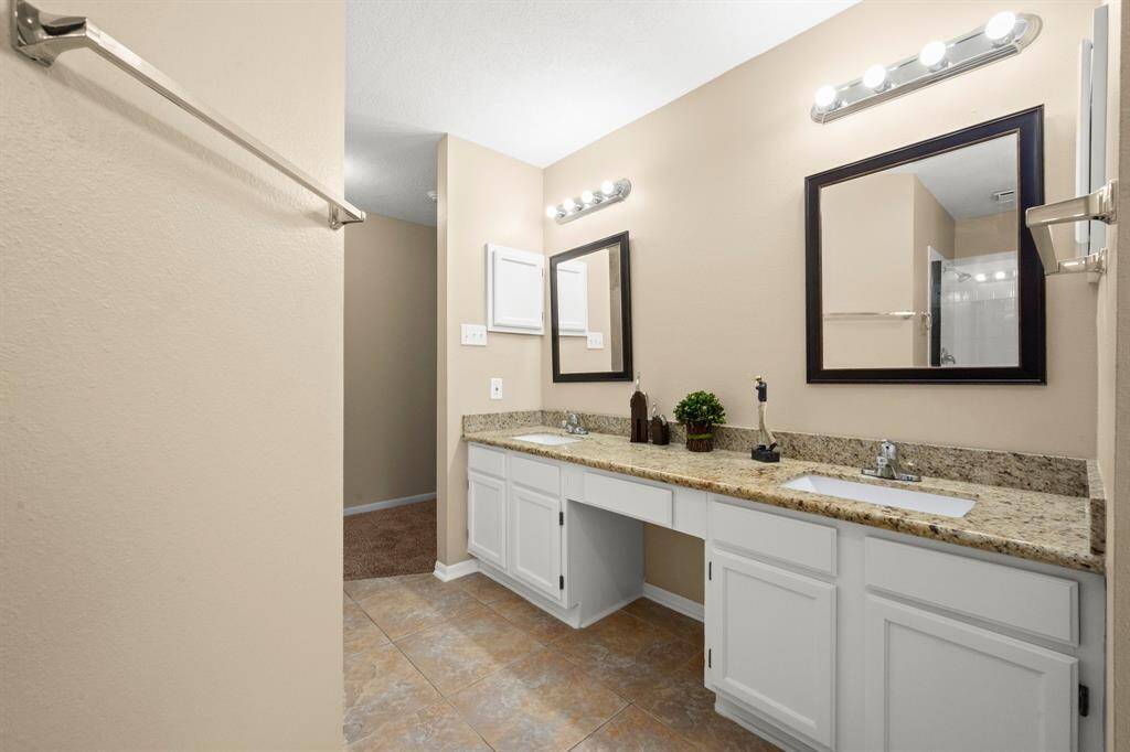 Updated primary bath with 2 sinks plus sit-down vanity.