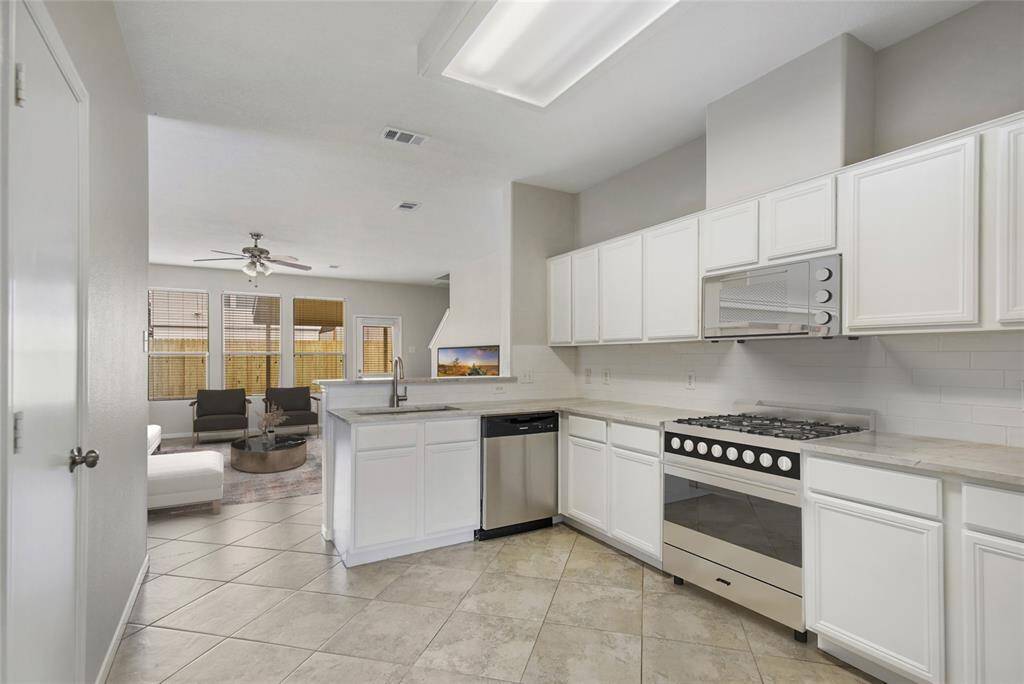 This picture has been Virtually staged.The kitchen has recent appliance updates: Stove, & built-in microwave, garbage disposal, and Dishwasher. Cabinets have been freshly painted, new Tajmahal Quartzite & new sink fixture.  Lovely and extremely efficient kitchen.