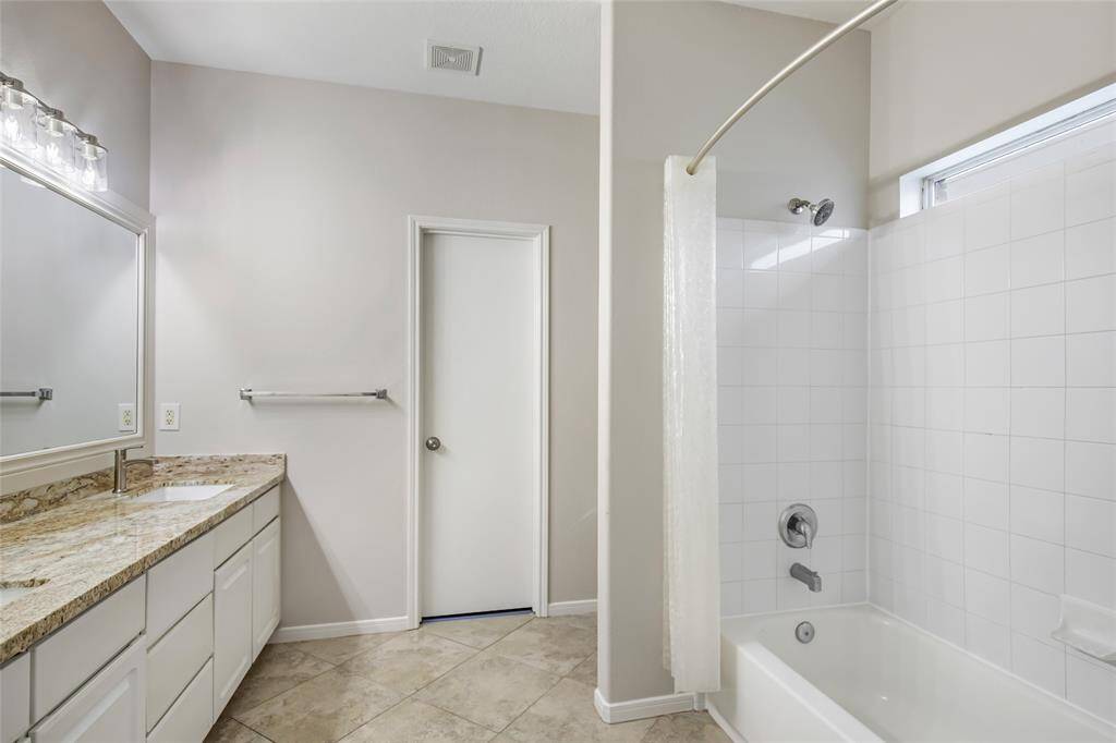 Primary bathroom with a tub/shower combo dual sinks & new granite vanity tops