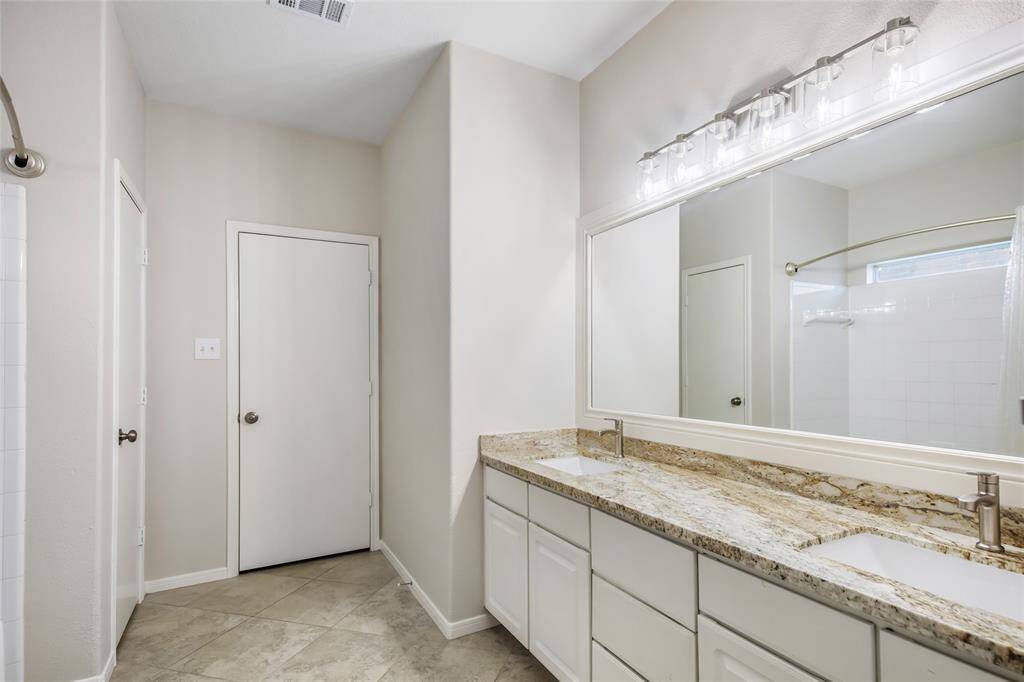 Primary bathroom has dual sinks, new lighting & new granite vanity tops
