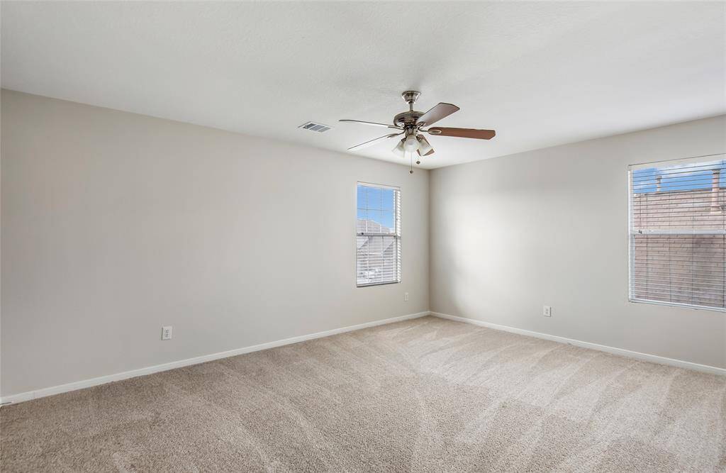 Bedroom with new carpet, fresh paint, ceiling fan and 2 inch faux wood blinds.