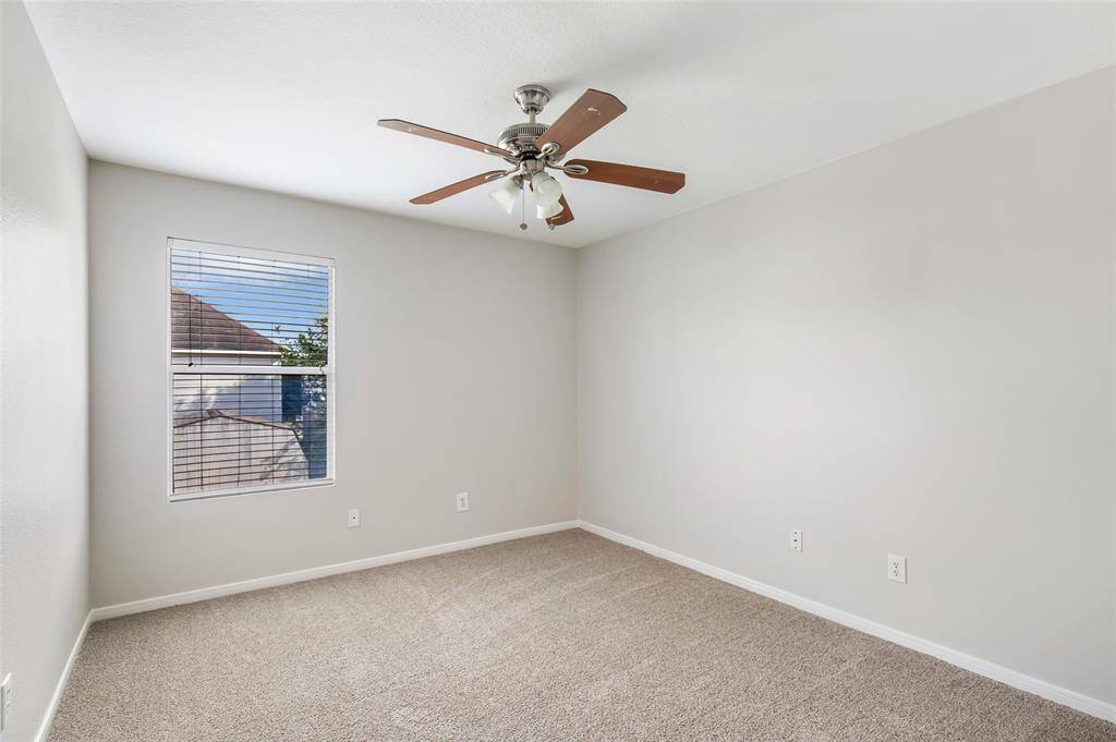 Bedroom with new carpet, fresh paint, ceiling fan and 2 inch faux wood blinds.