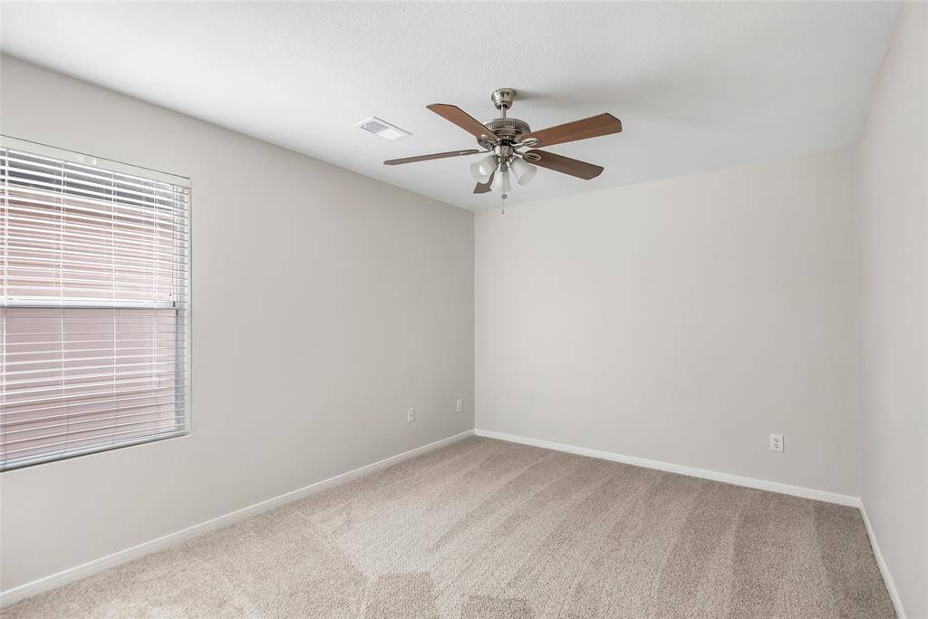Bedroom with new carpet, fresh paint, ceiling fan and 2 inch faux wood blinds.