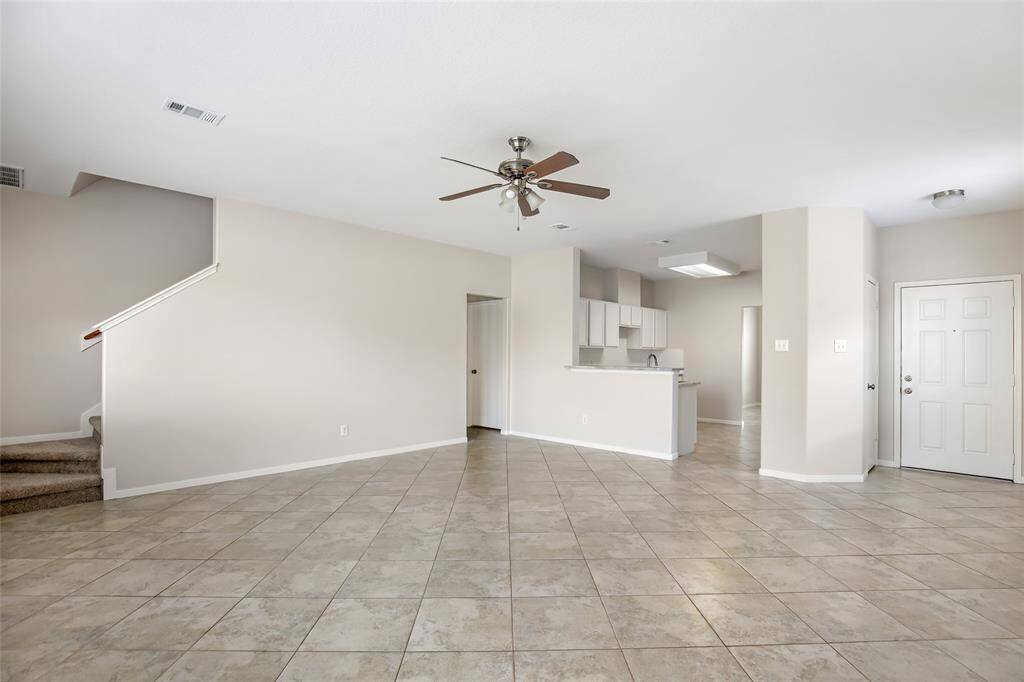 Living room to Kitchen.  Beautiful diagonally set tile flooring, ceiling fan and 2 inch faux wood blinds.  Upgrades include:  Wood looking vinyl plank floors, New paint, New appliances, updated fixtures, pressure washing, 2 inch faux wood blinds, some new plumbing fixtures, and light fixtures.