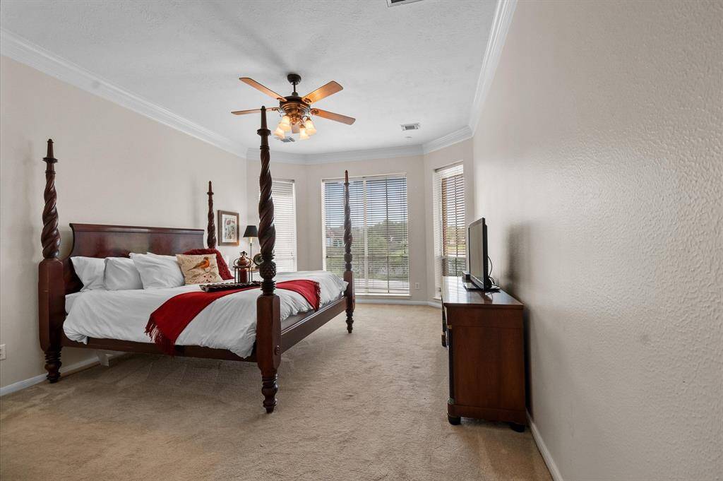 The primary bedroom has a bay window looking out to the pool and water and is very light and bright.