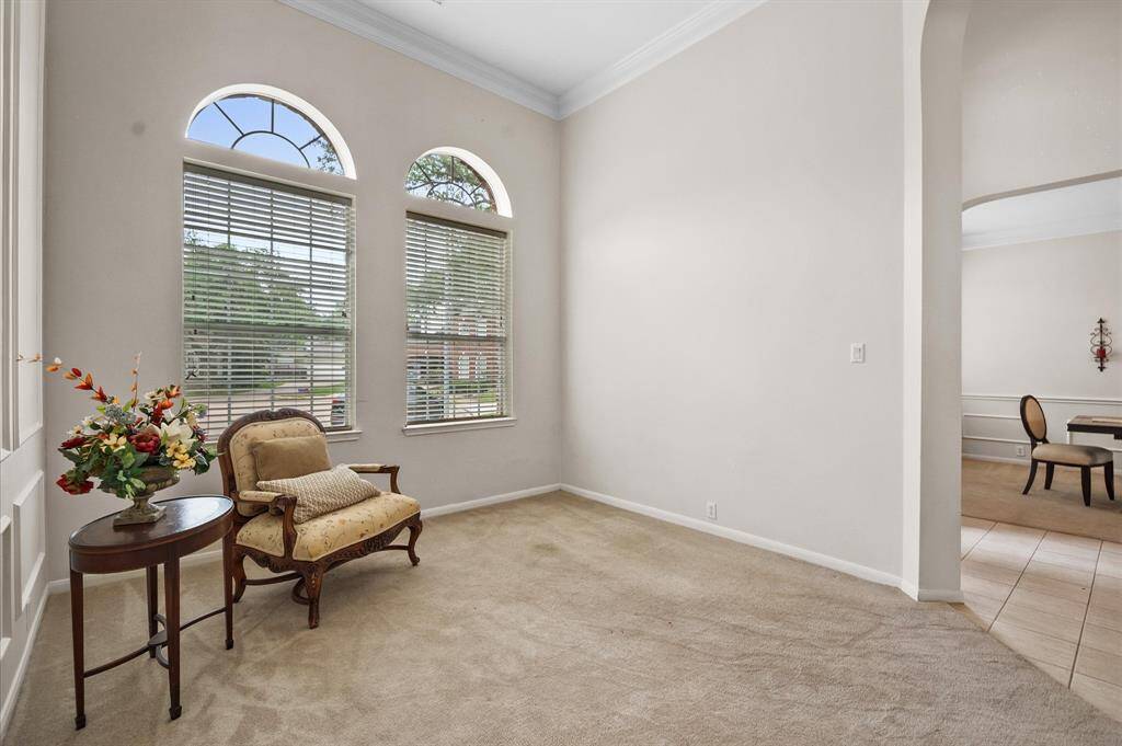 Formal living room has 12' ceilings and two arched windows.