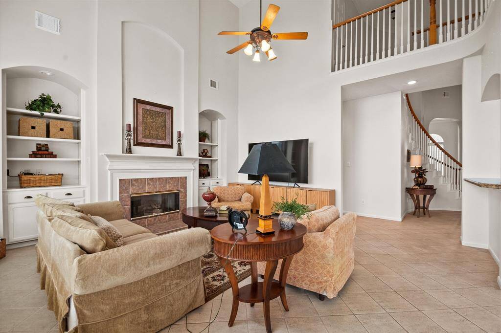 Virew of the family room with two story ceiling and a fireplace  flanked by two built in  units.