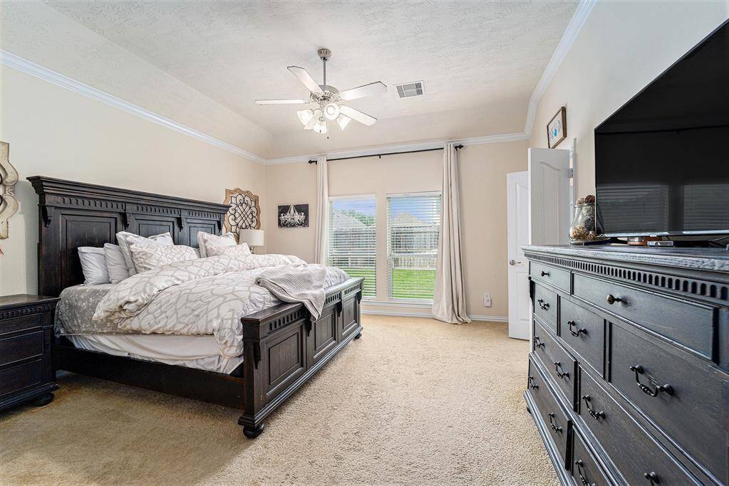 Spectacular primary bedroom features high ceilings, great views of the backyard, and a private en suite.