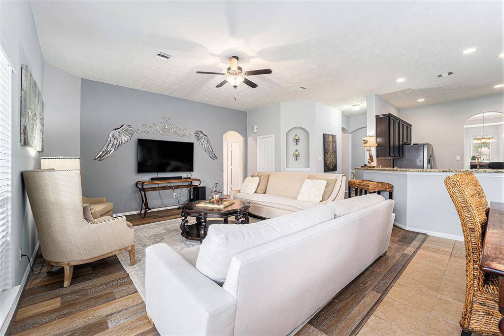 Charming living room presents high ceilings and seamlessly flows into the kitchen.
