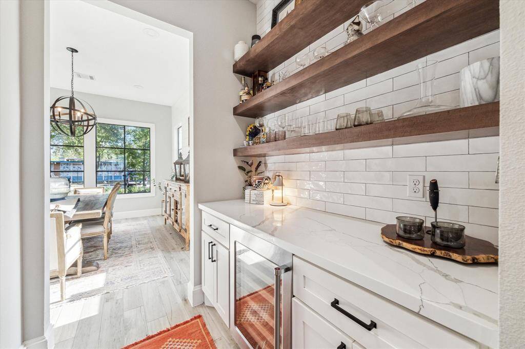 This home features a bright, open-concept living area with a modern kitchen, large island, and bar seating.