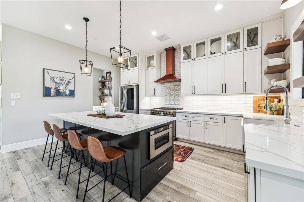 The open layout leads to a spacious living area with large windows, creating a warm and inviting atmosphere.