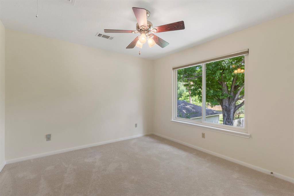 This neutral secondary bedroom features another large Andersen window with pretty views of your private back yard.