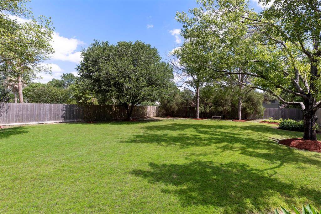 The back yard is fully fenced and features abundant mature trees that offer shade and beauty.