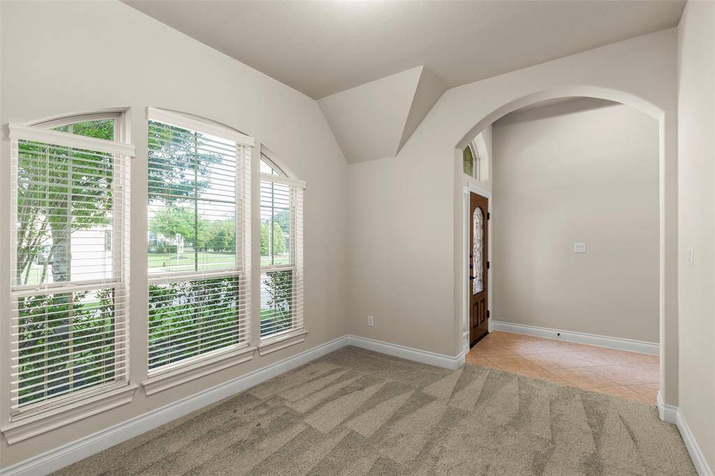 Showcases a Well-lit Home Office/Study with a Trio of Large Arched Windows