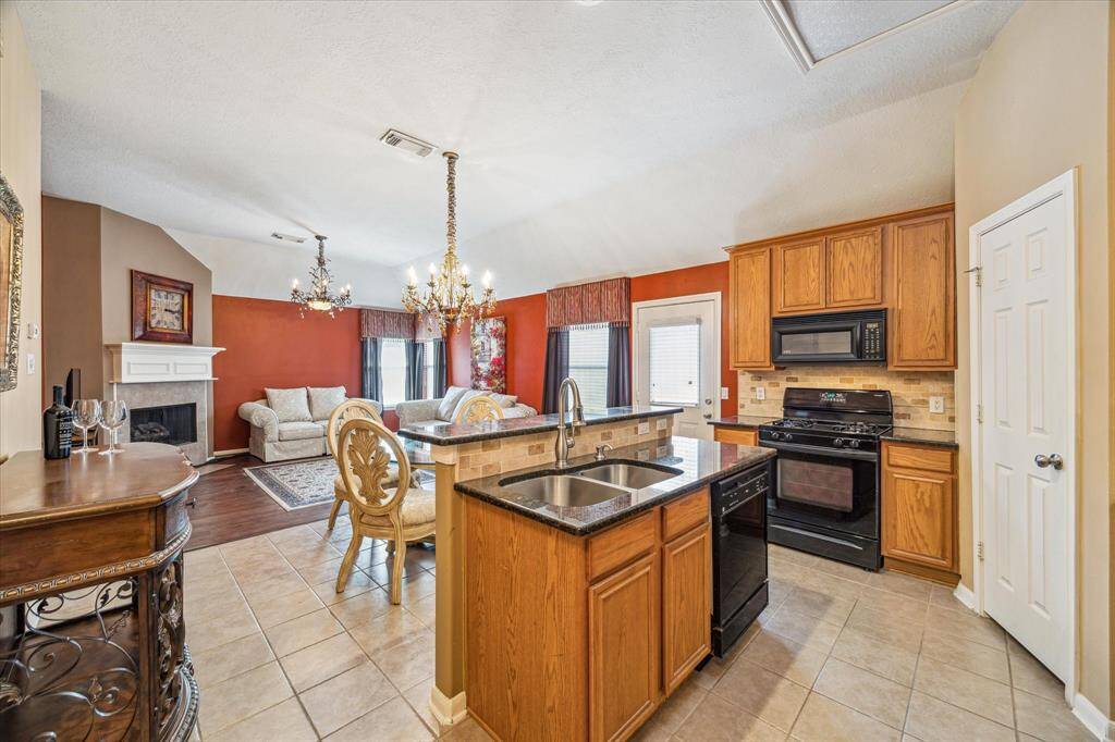 Kitchen with granite countertops, open to dining and living room.