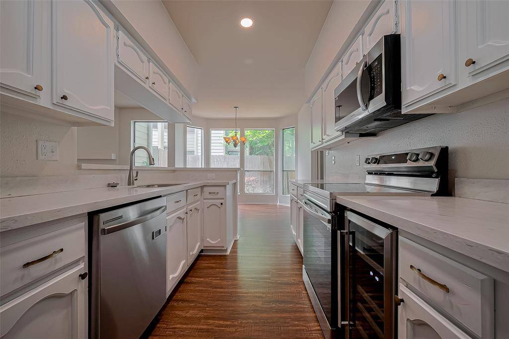 Elevate your culinary experience in a stunning kitchen featuring sleek quartz countertops, modern stainless steel appliances, and a stylish wine fridge ready to store favorite vintages.